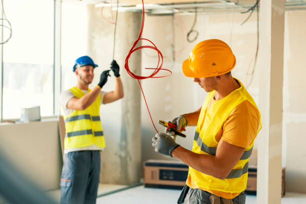 Licensed electrician installing commercial electrical panel in Cambridge building