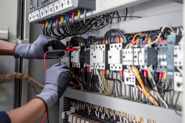 Professional electrician installing new wiring inside commercial building safely